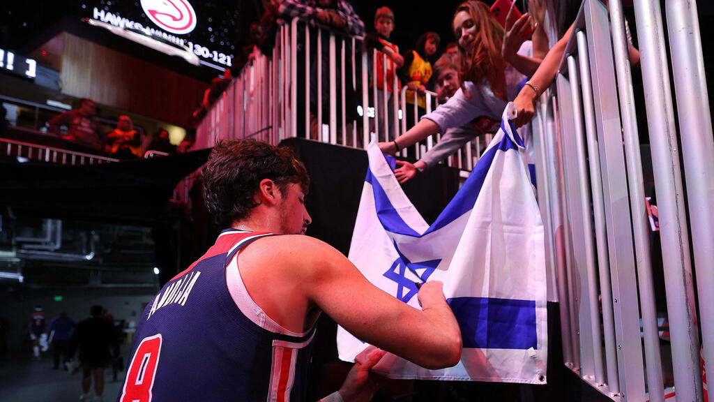 Deni Avdija greets Israeli fans in Washington (Photo: Kevin C. Cox / Getty Images / AFP) אבדיה חותם על דגל ישראל